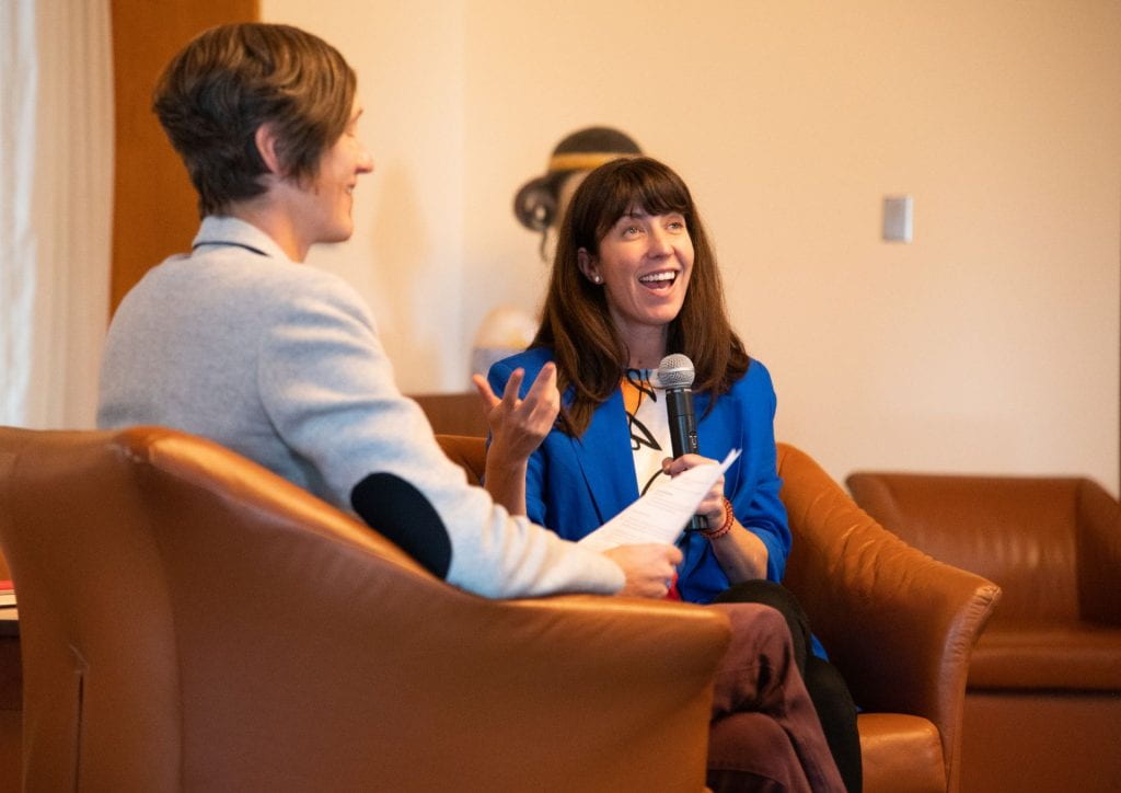 Francesca Tripodi speaks with Kate Starbird during an event. The two are seated.
